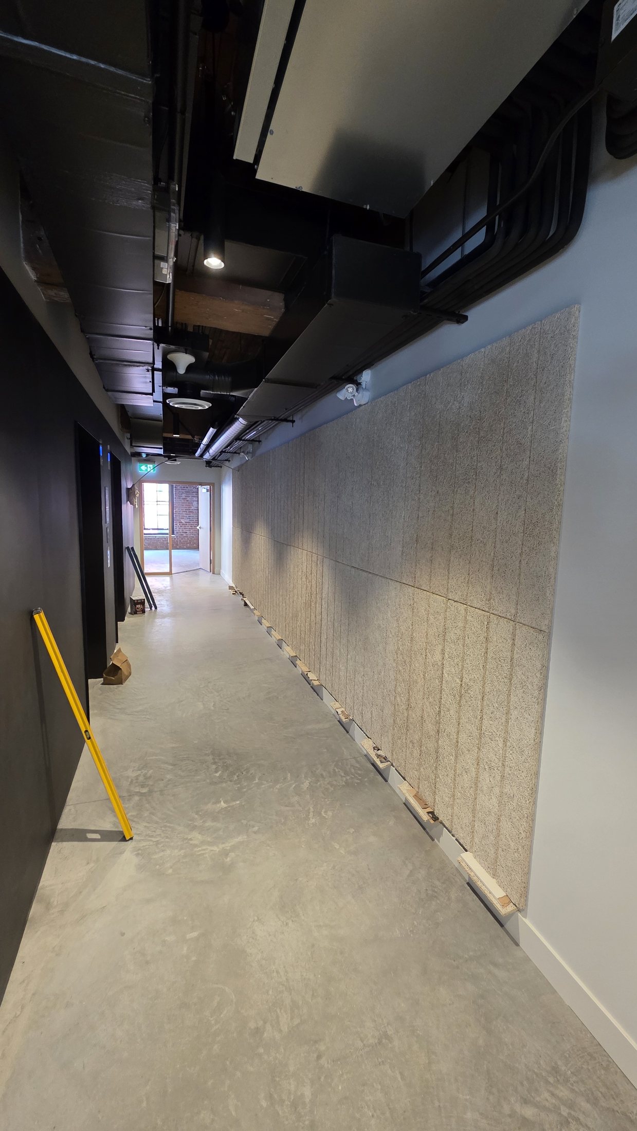 Tectum acoustic feature wall installation progressing through the 837 Beatty Street corridor.