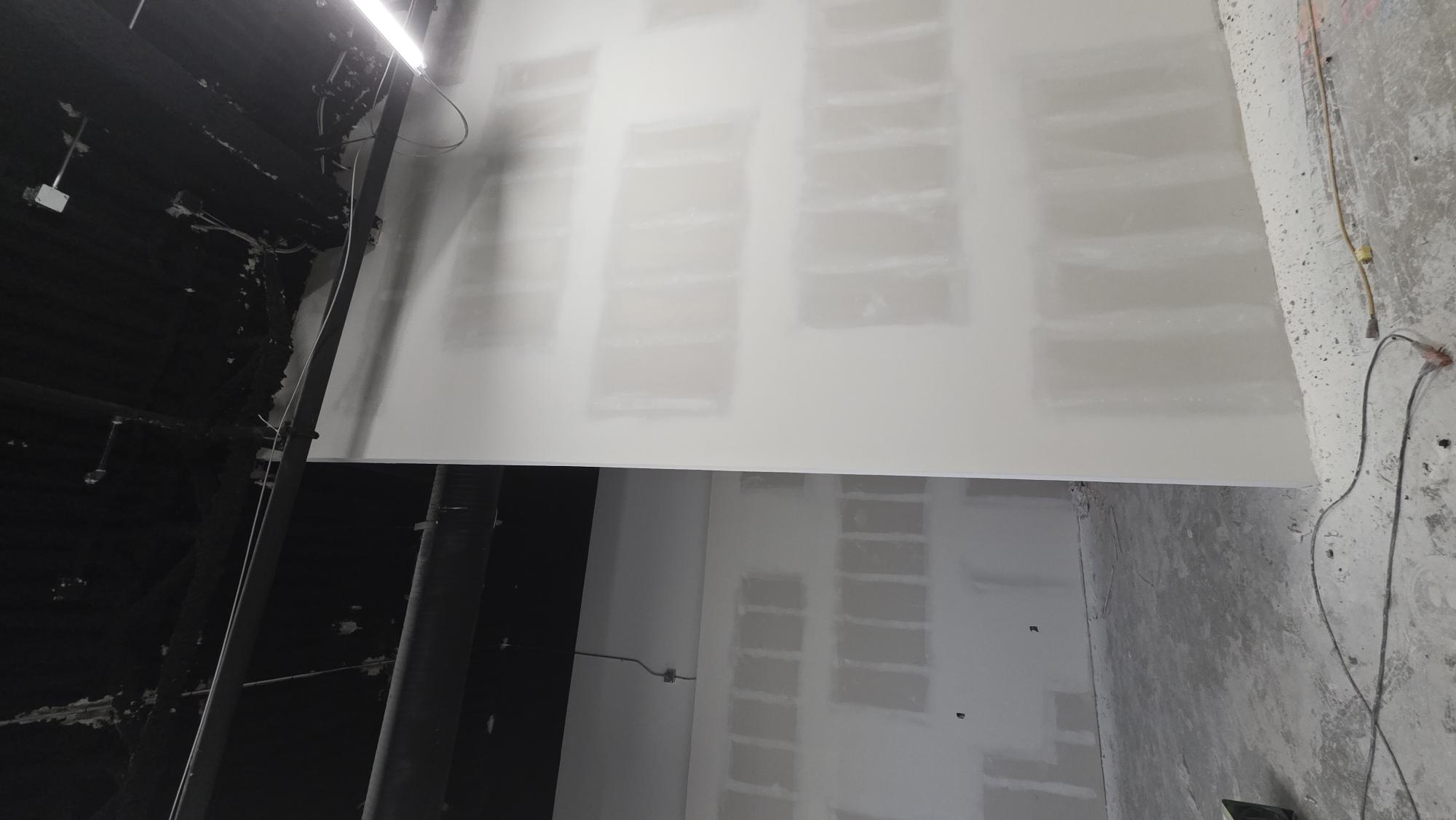 Club Champion drywall and T-bar progress — final sanding stage 1.