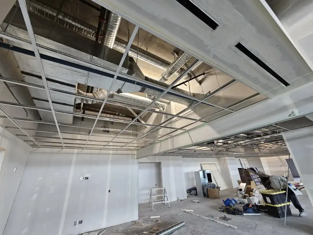 Suspended T-bar grid during a commercial ceiling installation.