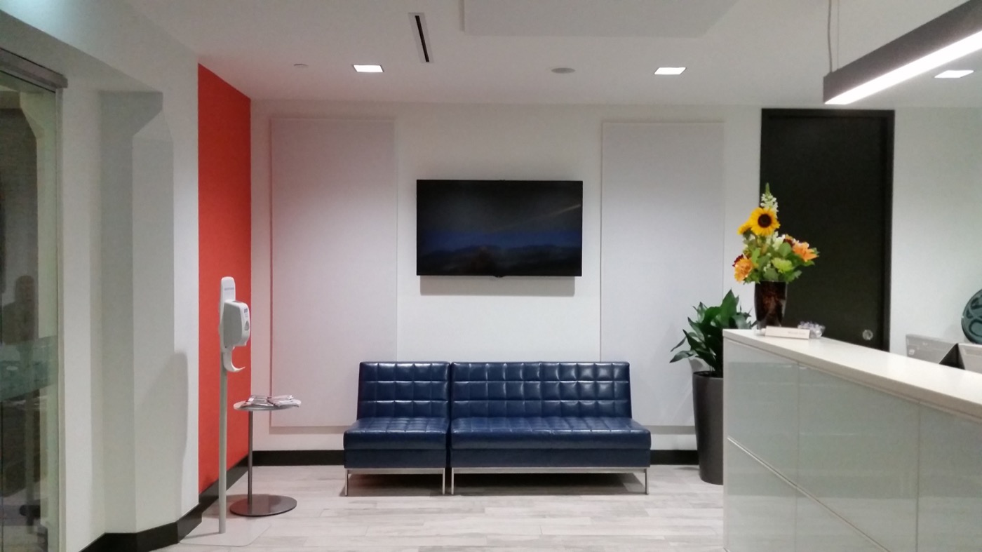 Completed commercial reception area with acoustic ceiling panels and integrated lighting.