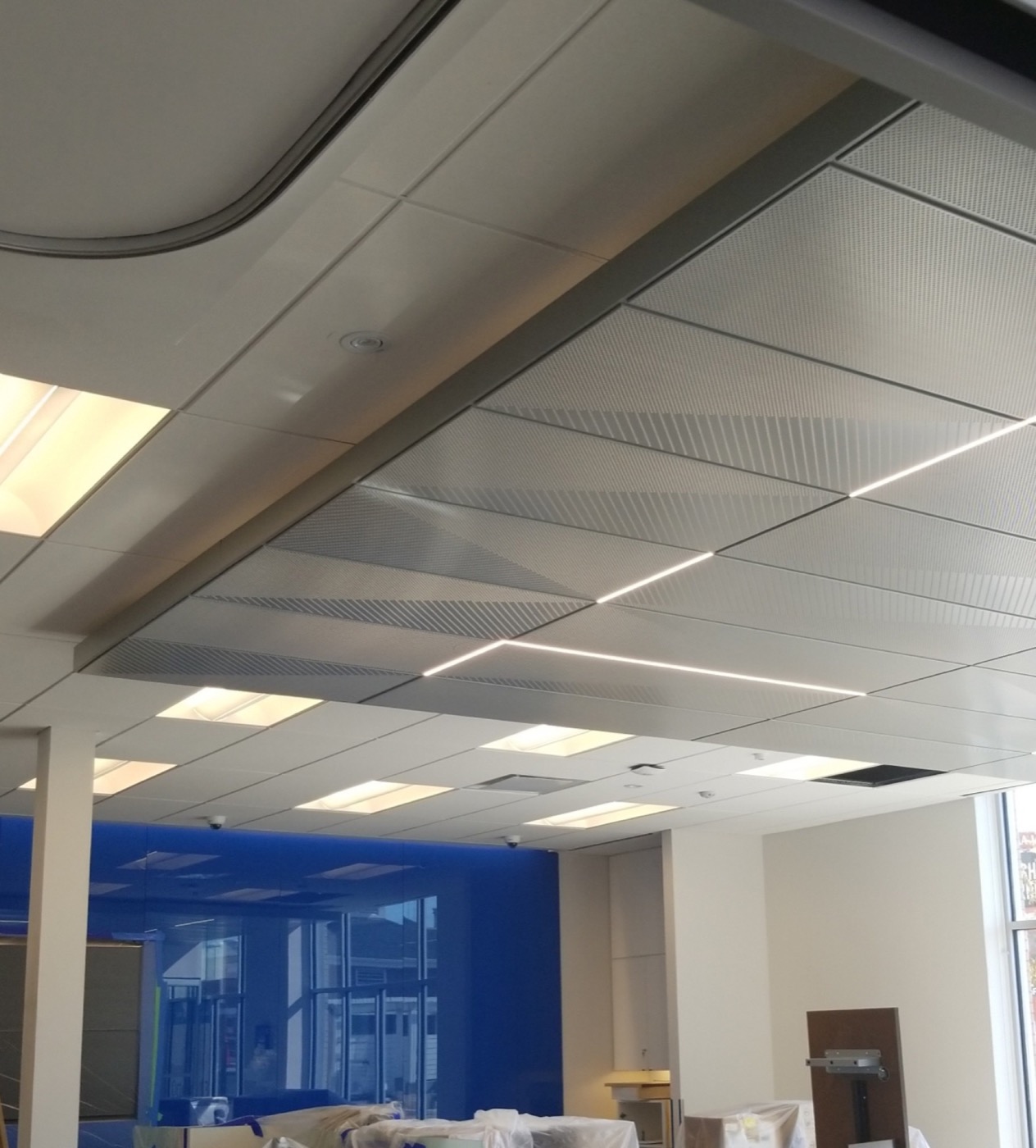 Curved suspended ceiling feature with acoustic panels in a completed commercial interior.