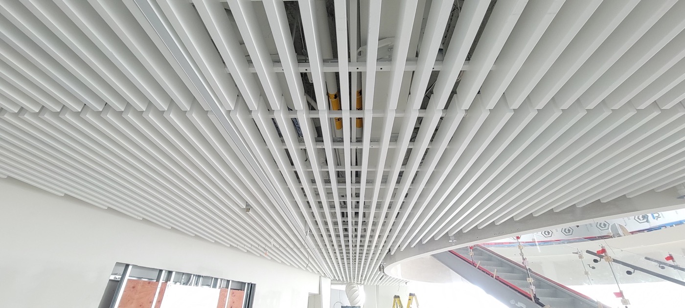 Linear metal ceiling slats installed across a commercial interior.