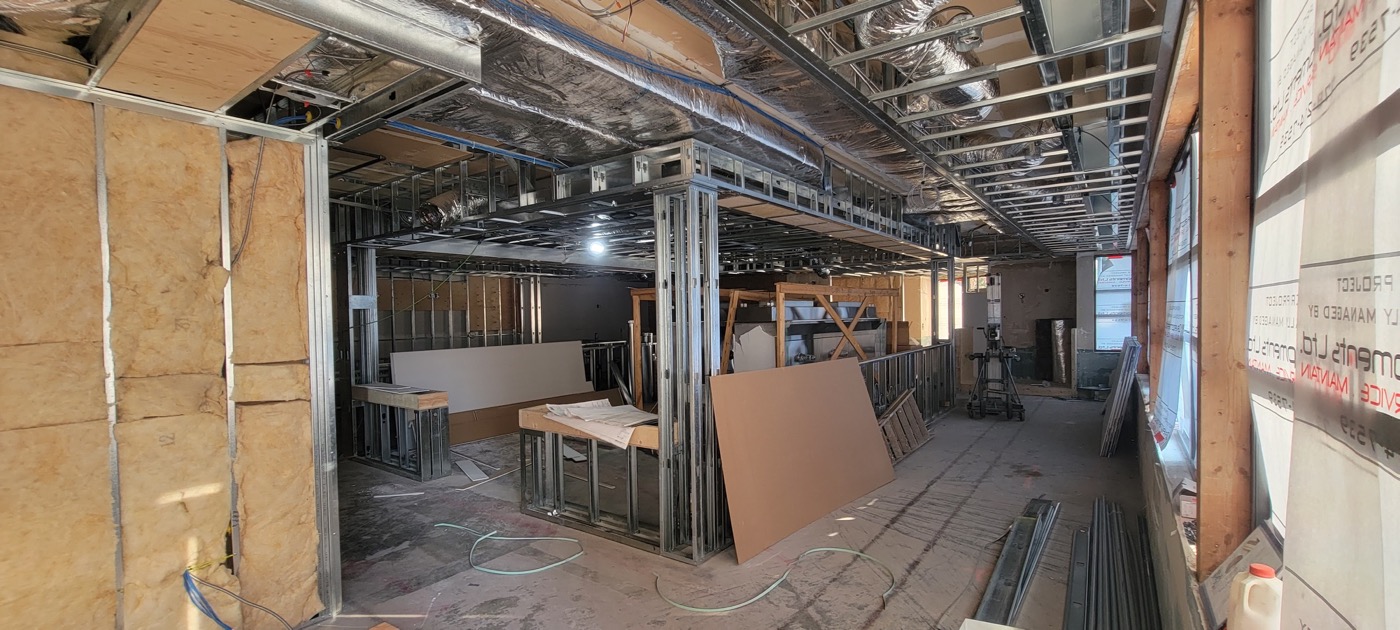 Commercial tenant improvement with framing and ceiling services exposed during construction.