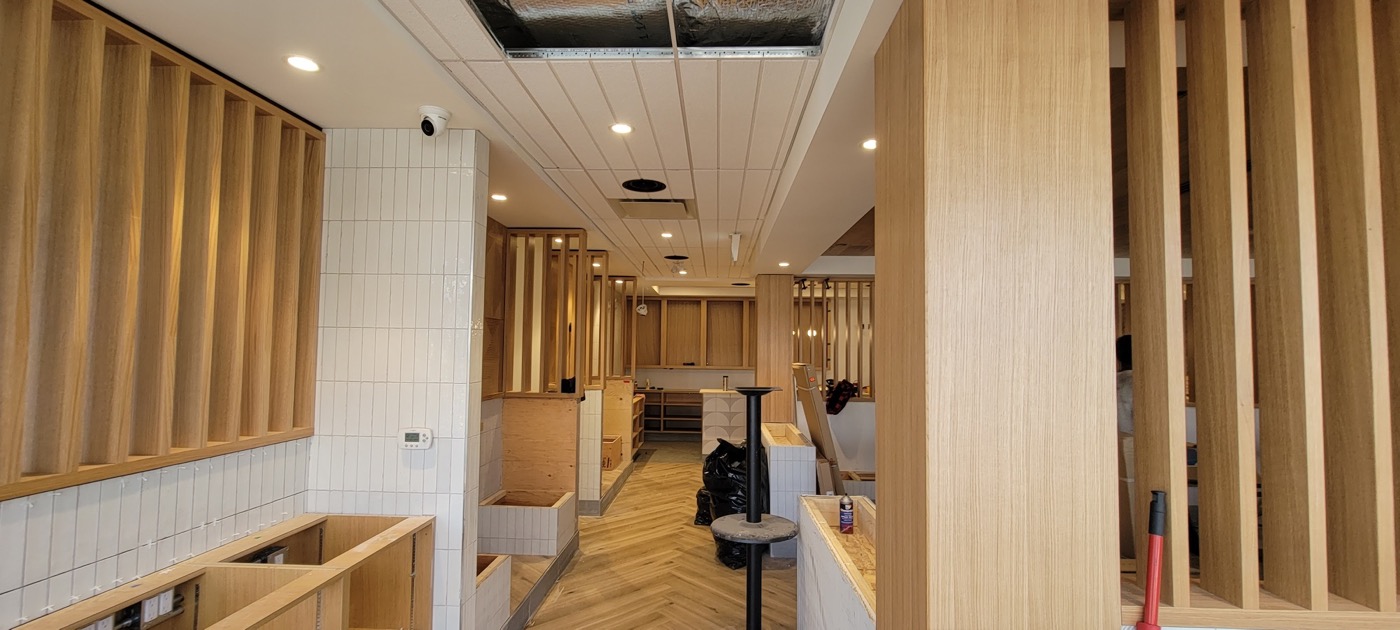 Finished wood-slat feature wall and ceiling inside a commercial interior.