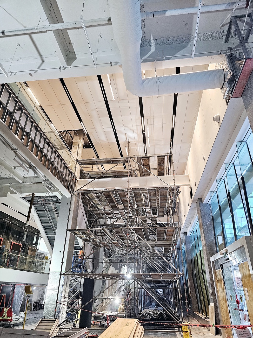 Suspended ceiling work progressing through a commercial corridor.