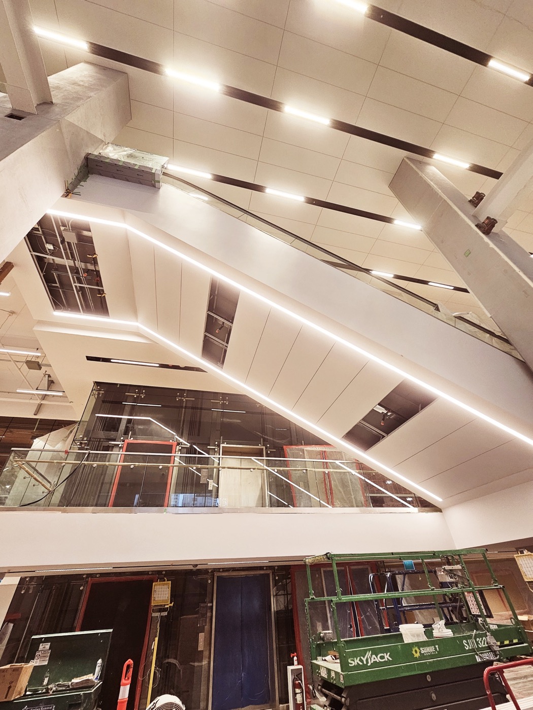 Curved specialty ceiling with linear panels and integrated strip lighting.