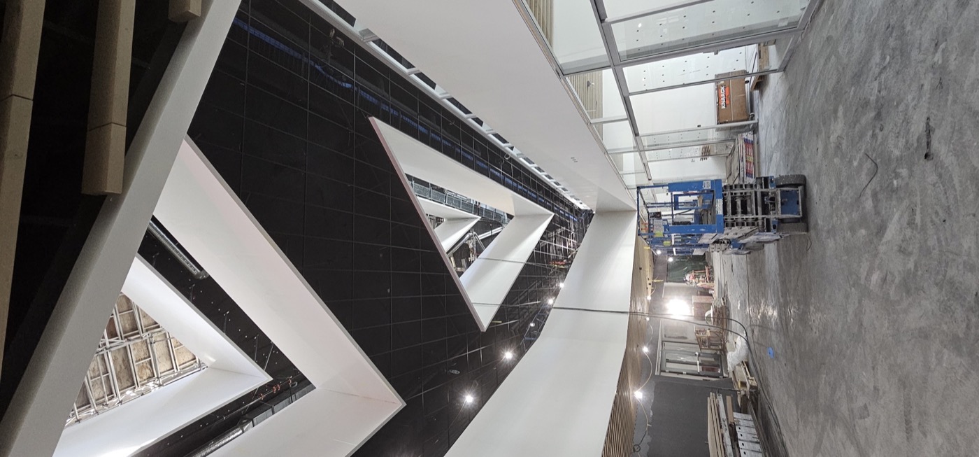 Black and white geometric specialty ceiling installation in progress.