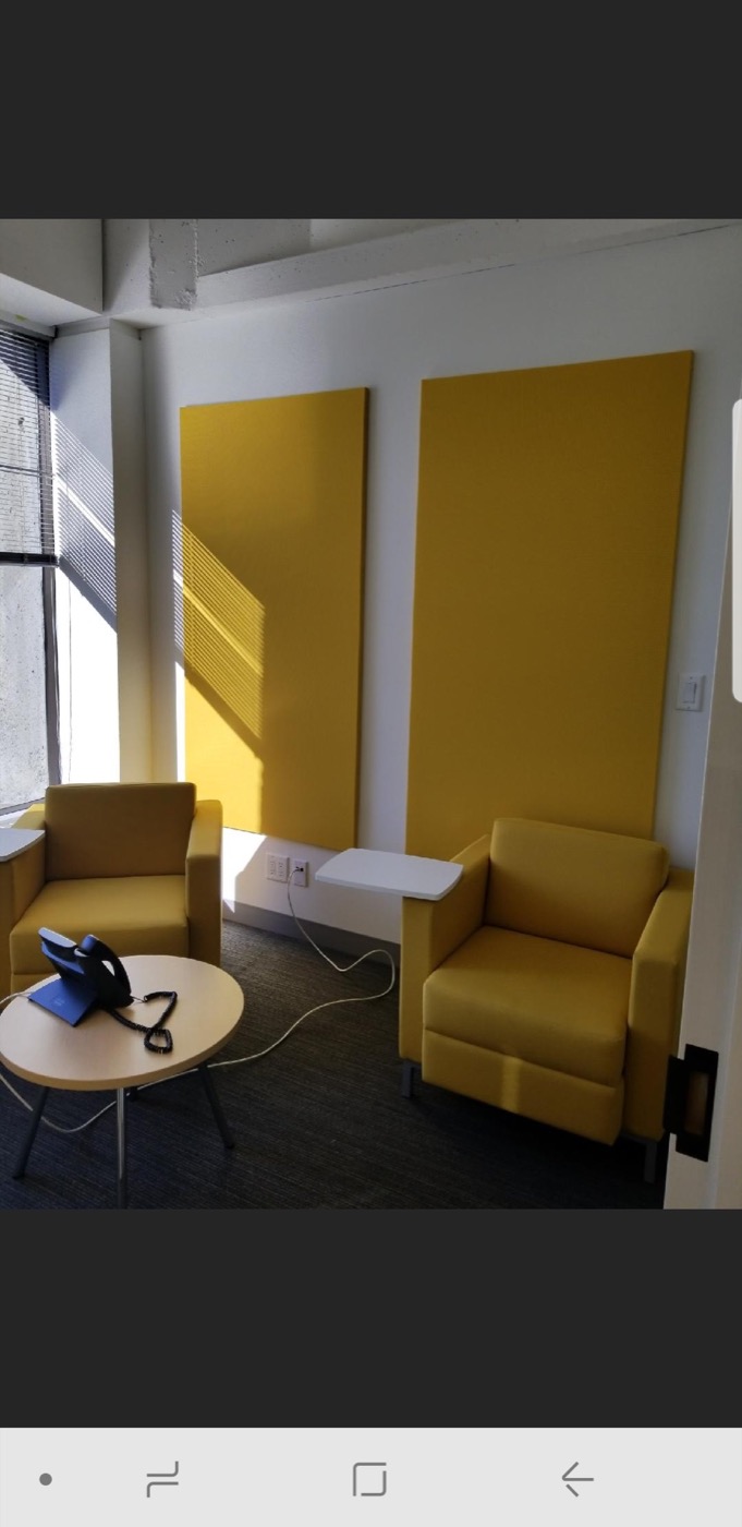 Finished yellow acoustic wall panels in a commercial meeting and seating area.