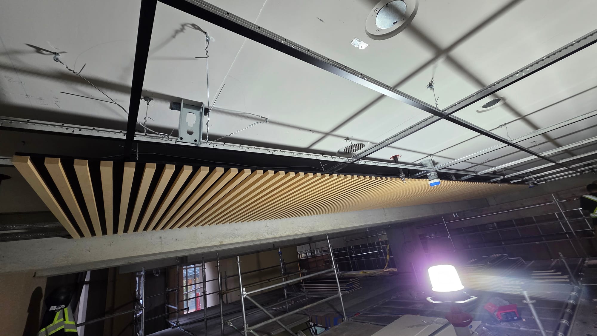 Suspended wood-slat feature ceiling installed in a commercial interior.