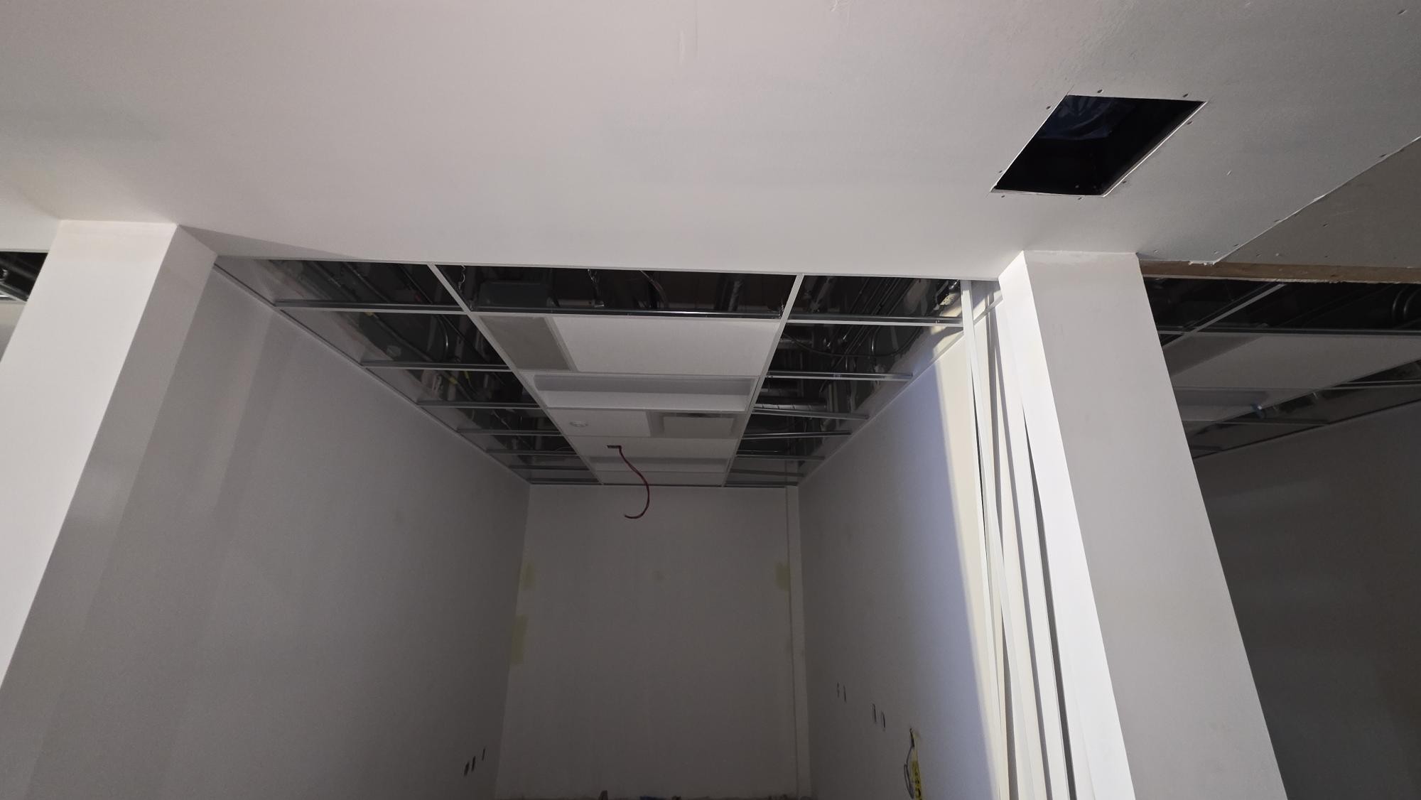 A closer room-edge view shows the transition between a finished surrounding surface and the open ceiling area.